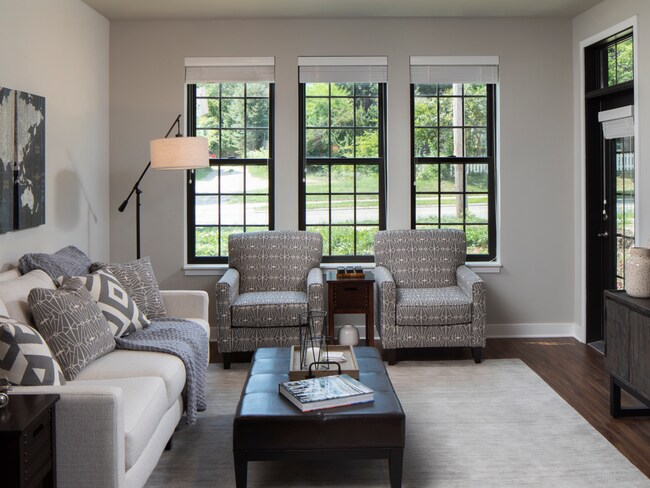 Sala de estar de concepto abierto con tres ventanas de Arrabelle Apartments - Arrabelle Apartments