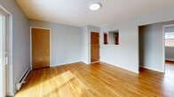 Located at 321 Crowells Rd in Highland Park, NJ, this single-floor, 3-bedroom, 2-bathroom residence offers a practical and well-maintained layout. Warm hardwood flooring runs throughout the main living areas and bedrooms, lending a consistent, cohesive feel to the space. The combined kitchen and living room serves as the heart of the home, with the living area featuring sliding glass doors that open to a private balcony, allowing natural light to fill the room. The kitchen is equipped with warm-toned wood cabinetry, dark granite-style countertops, a white tile backsplash, and stainless steel appliances including a gas range and dishwasher. The primary bedroom includes a ceiling fan and multiple closet doors, while the additional bedrooms feature baseboard heating and ample natural light from windows with exterior views. One bathroom offers a clean, white full tub-shower combination, while the second features a standalone vanity with an oval mirror, a window for natural light, and a separate shower enclosure. A connecting hallway ties the rooms together efficiently. The neutral gray walls throughout provide a clean, move-in ready backdrop suitable for a variety of interior styles.