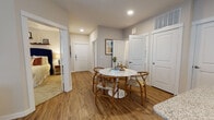 This single-story residence offers a thoughtfully designed layout that balances open communal spaces with private retreats. The living room provides a welcoming atmosphere, featuring wood-look flooring, large windows with blinds, and a glass door that invites natural light throughout the space. The open layout flows seamlessly into the dining area, which centers around a marble-top round table and connects directly to the kitchen.

The kitchen is outfitted with white shaker-style cabinetry, granite countertops, a kitchen island, and stainless steel appliances including a refrigerator with ice maker, electric range, and over-the-range microwave. Recessed lighting and wood-look flooring carry through this space consistently.

Two bedrooms provide comfortable accommodations, each featuring plush carpet, ceiling fans with lighting, and large windows that bring in natural light. The primary bedroom is notably spacious with room for generous furniture arrangements.

Two full bathrooms serve the residence, each featuring granite or stone-style countertops, white cabinetry, and shower-tub combinations. An in-unit laundry area is also visible, adding everyday convenience. A defined entryway corridor connects all areas, reinforcing the home's functional and organized flow.