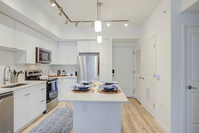 East Phase Kitchen with white cabinetry, white countertops, stainless steel appliances, and hard surface flooring - Avalon Miramar Park Place