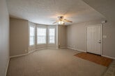 This single-floor home offers a functional and well-organized layout, thoughtfully designed for comfortable everyday living. The kitchen serves as a central hub of the home, featuring warm honey-toned oak cabinetry with ample upper and lower storage, light countertops, and tile flooring. It is fully equipped with a full-size refrigerator with ice and water dispenser, a black dishwasher, and a range with oven. The kitchen opens seamlessly toward the living area, which features a combination of tile and carpet flooring and a ceiling fan overhead, creating an airy, connected feel. A dedicated laundry area with washer and dryer hookups is conveniently located just off the kitchen. The bedrooms are carpeted and bathed in natural light from windows with blinds, each featuring ceiling fans for added comfort, and closets for storage. The home includes two full bathrooms, both featuring a tub-shower combo. One bathroom includes oak cabinetry, a vanity with sink, and tile flooring, while the second offers a clean, minimal design with neutral tones. Throughout the home, neutral gray and beige wall tones create a cohesive, move-in ready atmosphere with a practical and livable character.