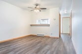This tri-level home in Madison, Wisconsin offers a well-organized layout spread across three floors, providing comfortable separation between living and sleeping areas. The main level features an open-concept kitchen and living room bathed in natural light from large windows with blinds. The kitchen is equipped with white shaker-style cabinetry, a gas range, dishwasher, refrigerator, and a stainless steel sink, complemented by light hardwood-style flooring throughout. The living area is highlighted by a ceiling fan with light fixture and a pass-through bar detail connecting to the kitchen.

The two bedrooms are carpeted and bright, each featuring windows with natural light, closets with warm wood bi-fold doors, and floor vents for heating. The primary bedroom offers a comfortable footprint with its own closet. Both bathrooms are well-appointed — one features a full tub/shower combo with large-format tile surround and warm wood flooring, while the second is a more compact full bath with accessibility grab bars. Additional features include multiple staircases connecting the floors, two closets for storage, and a utility room for added convenience. The space presents a clean, neutral palette throughout, making it move-in ready.