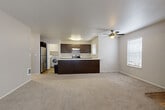 Located at 12800 SE 7th St in Vancouver, WA, this single-floor, 2-bedroom, 2-bathroom home offers a well-designed layout with a comfortable and functional living environment. The open-concept living and kitchen area serves as the heart of the home, featuring plush carpeting, a ceiling fan with light fixture, and a tile-surround fireplace that adds warmth and character. Multiple windows with blinds allow natural light to fill the space. The kitchen is well-appointed with dark espresso cabinetry, stainless steel appliances including an electric range and refrigerator, light countertops, and a peninsula with an integrated sink—ideal for both cooking and casual dining. A dedicated laundry area with an in-unit washer is conveniently located adjacent to the kitchen. The primary bedroom is generously sized and includes a walk-in closet with built-in shelving. The secondary bedroom features dual windows with an outdoor view and a baseboard heater. Both bathrooms are finished with dark vanity cabinetry, white countertops, and wood-look flooring. The walk-in closet also houses the water heater. Neutral tones throughout create a clean, cohesive aesthetic across the entire home.