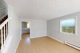 Located at 350 Main St, Unit 1 in Spencer, MA, this 2-bedroom, 1-bathroom unit spans three floors, offering a well-organized and functional layout. The main living level features a bright living room with light wood-tone flooring, textured ceilings, and a window that brings in natural light and outdoor greenery views. Baseboard heating is present throughout, ensuring year-round comfort. The kitchen is equipped with a stainless steel refrigerator, white cabinetry, and light flooring, with a window providing additional natural light and a dedicated dining area. The full bathroom is clean and straightforward, featuring a tub/shower combo, a white vanity, and tile-style flooring. Both bedrooms are carpeted and feature textured walls, windows with views of the surrounding greenery, and baseboard heating. The primary bedroom is notably spacious, while the second bedroom is cozy and well-proportioned. A basement level adds valuable extra space, and a dedicated closet provides additional storage. Outside, the property is surrounded by a well-maintained lawn, mature trees, and lush landscaping, with a lattice-skirted covered area accessible from the exterior.