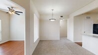 Located at 8818 Travis Hills Drive in Austin, TX, this single-story, one-bedroom, one-bathroom home offers a thoughtfully designed layout across a comfortable footprint. The space opens with a welcoming entrance that flows into two distinct living areas — one featuring rich hardwood flooring, vaulted ceilings, a ceiling fan, and large windows that fill the room with natural light, and a second carpeted living area illuminated by a pendant light fixture with arched architectural detailing that adds character throughout.

The kitchen is well-appointed with warm wood cabinetry, white countertops, a tile backsplash, and black appliances including a range, microwave, and refrigerator. A peninsula with a sink and breakfast bar counter connects the kitchen to the living space, enhancing the open flow of the home.

The carpeted bedroom benefits from vaulted ceilings, a ceiling fan, and a natural light source through a arched window, creating a calm and airy retreat. The walk-in closet offers built-in wire shelving for generous storage. The bathroom features warm wood vanity cabinets, a wide mirror with overhead lighting, hardwood flooring, and a full soaking tub. A hallway connects all areas cohesively, completing this well-balanced and functional home.