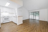 Located at 300 Hilary Way in Vallejo, California, this one-bedroom, one-bathroom residence offers a well-designed layout across a single floor. The living room is a standout space, featuring dramatic vaulted ceilings that amplify the sense of openness, warm light wood flooring, a ceiling fan, and a baseboard heating system. Sliding glass doors lead directly to a private balcony, bringing in natural light and pleasant outdoor views of surrounding greenery.

The adjacent dining area flows seamlessly from the living space, maintaining the same light wood flooring and open feel. The kitchen is bright and functional, outfitted with white shaker-style cabinetry extending to the ceiling, white appliances including a range and refrigerator, a stainless steel sink, light countertops, and a skylight that fills the space with natural light. A peninsula counter adds convenience.

The bedroom is a comfortable retreat featuring plush carpeting, a window with views of mature trees, a baseboard heater, and access to two closets. The bathroom is clean and modern, with light wood-style flooring, a white vanity with ample storage, a large mirror, and a full tub-shower combination. A hallway connects the main areas of the home efficiently, completing this well-appointed residence.