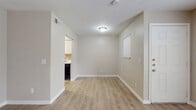 This single-floor residence offers a clean, neutral aesthetic with a practical and comfortable layout. The open living area is finished with light-toned laminate wood flooring that extends throughout the main living spaces, reflecting natural light from multiple windows dressed with horizontal blinds. The entry flows naturally into a spacious living room, providing a bright and welcoming atmosphere.

The kitchen is well-appointed with crisp white cabinetry, marble-patterned countertops, a double stainless steel sink with a brushed nickel faucet, and black appliances including an electric range. A range hood and ample counter space make the kitchen both functional and visually clean.

The bedrooms feature plush wall-to-wall carpeting and are equipped with ceiling fans with integrated lighting, offering comfort and airflow year-round. Each bedroom includes a window with blinds, allowing for natural light while maintaining privacy.

The bathroom is neatly finished with a white vanity, marble-style countertop, a large mirror, and a shower-tub combination. Light wood-look flooring ties the bathroom's design together cohesively.

A dedicated laundry area is accessible from the main living space, adding everyday convenience. Throughout the home, consistent warm-beige wall tones and white trim create a cohesive, move-in-ready environment.