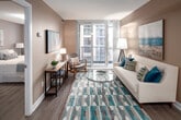 Located at 7 Summerland Terrace in Toronto's sought-after M9A neighbourhood, this well-appointed unit offers a thoughtfully designed single-floor layout with a neutral, contemporary palette throughout. The open-concept kitchen is outfitted with warm maple cabinetry, ample upper and lower storage, a peninsula with a built-in sink and light stone countertops, and full-size appliances including a refrigerator and electric range. The kitchen flows seamlessly into the combined dining and living area, where hardwood-style flooring, track lighting, and a large sliding glass door lead to a private balcony with views of the surrounding urban landscape. The living room is bright and welcoming, benefiting from generous natural light. Two bedrooms provide comfortable retreats; the primary bedroom features mirrored sliding closet doors that enhance the sense of space, while the second bedroom offers a broad window with views of the cityscape. A full bathroom with colourful accent shelving is conveniently accessible from the entry foyer, which features tile flooring for easy maintenance. The warm taupe tones, textured ceilings, and consistent finishes lend a cohesive and polished feel to the entire space.