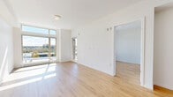 Located at 803 Village Drive in Port Coquitlam, BC, this well-designed two-bedroom, two-bathroom residence offers a bright and contemporary living experience across a single floor. The open-concept living, dining, and kitchen area serves as the heart of the home, bathed in natural light through expansive floor-to-ceiling windows that frame outdoor views of the surrounding landscape. Light-toned hardwood flooring runs throughout, complementing the clean white walls and modern aesthetic.

The kitchen is a standout feature, showcasing rich dark wood cabinetry, granite countertops, a large central island with an undermount sink, and a full suite of stainless steel appliances including a dishwasher, range, and refrigerator. Recessed lighting and under-cabinet fixtures ensure the space is both functional and visually polished.

The bedrooms are generously proportioned, with the primary bedroom offering notable space and large windows with scenic views. Both bathrooms are finished in a clean, contemporary style, with the main bath featuring full-size tile surround, a soaker tub and shower combination, and wood-toned vanity cabinetry. Additional conveniences include three closets, in-unit laundry, and a private outdoor balcony accessible from the living area.