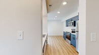 Located at 259 S Teller St in Lakewood, Colorado, this thoughtfully updated one-bedroom, one-bathroom unit offers a clean, modern aesthetic across a single floor. Warm-toned luxury vinyl plank flooring runs continuously throughout, lending a cohesive and contemporary feel to every room.

The open living room is bright and inviting, anchored by a sliding glass door that fills the space with natural light and provides direct views of the greenery outside. The kitchen is a standout feature, outfitted with bold blue cabinetry, matte black hardware, white tile backsplash, light quartz countertops, and a full suite of stainless steel appliances including a range, over-the-range microwave, and refrigerator.

The bedroom offers a comfortable, well-proportioned layout with a large window overlooking the exterior, plus access to a dedicated closet with built-in hanging storage. A second door in the bedroom provides additional connectivity to the hallway. The bathroom is cleanly designed with a wide vanity, gray cabinetry, a framed mirror, and updated light fixture. Two hallways connect the rooms efficiently, contributing to a practical and easy-to-navigate floor plan. The unit's crisp white walls and consistent finishes create a fresh, move-in-ready atmosphere throughout.