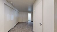 Located at Bayard Road in Pittsburgh's Oakland neighborhood, this one-bedroom, one-bathroom unit offers a practical and efficient layout across a single floor. The living area is carpeted and features neutral white walls, two windows with a radiator unit beneath them providing natural light and warmth, creating a simple, open feel. The generously sized bedroom — the largest room in the unit — is also carpeted and finished with clean white walls, offering ample space for furnishings. Two closets provide useful storage throughout the unit. The kitchen is equipped with warm-toned wood cabinetry spanning both upper and lower configurations, a gas range, a full-size refrigerator, a single-basin sink, and light-colored countertops. Tile flooring runs through the kitchen, adding durability to a functional cooking space. A window above the kitchen counter allows for additional natural light. The bathroom includes a full tub and shower combination with a curtain, a toilet, and a pedestal sink, all finished with tile flooring in a clean, minimal style. Throughout the unit, the consistent use of neutral tones and carpet in the main living spaces creates a cohesive and straightforward residential environment suited for everyday living.