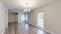 Located at 1150 Sigman Rd NE in Conyers, Georgia, this single-floor home offers a clean, modern interior designed for comfortable everyday living. Throughout the home, durable hardwood-style flooring in warm gray tones provides a cohesive and contemporary aesthetic, complemented by neutral-toned walls and crisp white trim.

The living area is open and well-lit, featuring multiple windows dressed with blinds that invite generous natural light. A second area adjacent to the main living space serves as a dedicated dining area, highlighted by an elegant brushed-nickel chandelier that adds a refined touch to the room. A glass-panel exterior door in this space provides additional natural light and outdoor access.

The kitchen is thoughtfully appointed with white shaker-style cabinetry, granite-look countertops, and a full suite of stainless steel appliances, including a refrigerator, range, microwave, and dishwasher. The layout is efficient and functional, with ample cabinet and counter space.

The bathroom features wood-look flooring, a granite-topped white vanity, a full tub-shower combination, and clean, neutral finishes throughout. Textured ceilings are present across the home, adding architectural character. The overall design is move-in ready, offering a well-maintained and updated interior in a convenient Conyers location.