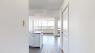 Located at 5600 Sheppard Ave E in Toronto's Scarborough district, this one-bedroom, one-bathroom unit offers a practical and well-appointed layout across a single floor. Distinctive parquet wood flooring runs throughout the living, dining, and bedroom areas, adding warmth and character to the space.

The combined kitchen and living area forms the heart of the unit. The kitchen is thoughtfully designed with white cabinetry, subway tile backsplash, light tile flooring, and a full suite of stainless steel appliances including a refrigerator, dishwasher, and range. A window above the sink brings in natural light. The adjacent living room is generously proportioned, featuring large windows that frame city views and allow abundant daylight to fill the room. A baseboard heating unit runs along the window wall.

The bedroom is a comfortable, well-lit room with a window overlooking the surrounding neighbourhood and a sliding mirrored closet that enhances the sense of space. The full bathroom is finished with large-format floor tiles, a dark wood vanity with a white countertop, a wall-mounted mirror, and a tub-shower combination with classic white subway tile surround. The overall aesthetic throughout the unit is clean and neutral, offering a bright and functional living environment.