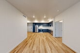 Located at 544 Alves Ln in Bay Point, CA, this single-story 3-bedroom, 2-bathroom home offers a thoughtfully designed layout with modern finishes throughout. The open-concept living, dining, and kitchen area serves as the heart of the home, featuring light-toned hardwood-style flooring that flows seamlessly across the space. The kitchen is a standout, outfitted with bold navy blue cabinetry, white countertops, a stainless steel refrigerator, range, and dishwasher, all illuminated by recessed lighting. The generous open floor plan provides ample room for both dining and relaxing. Three well-proportioned bedrooms feature the same warm flooring, neutral walls, and good natural light, with some rooms offering outdoor views through large windows. Each bedroom includes dedicated closet space. The two bathrooms are clean and functional; one features an accessible tub-shower combination equipped with grab bars and a fold-down bench, while the other offers a standard tub-shower setup. A dedicated laundry area and a connecting hallway add to the home's practical layout. The overall ambiance is bright, clean, and contemporary, making this an efficient and comfortable living space.