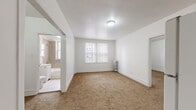 Located at 5501 W Washington Blvd in Chicago's West Side, this two-bedroom, one-bathroom unit offers a functional and straightforward layout across a single floor. The space is finished throughout with warm tan carpeting in the living and bedroom areas, while the kitchen and bathroom feature tile flooring.

The spacious primary bedroom receives natural light through a double window and is equipped with a classic cast-iron radiator for heating. The second bedroom is similarly carpeted and bright, offering its own closet with built-in shelving for ample storage. Both rooms feature clean white walls and simple, neutral finishes.

The kitchen is efficiently designed with warm wood cabinetry, a dark granite-style countertop, a double sink, and a white gas range, providing all essential cooking accommodations. A full-size refrigerator is also included.

The bathroom is finished with taupe wall tiles surrounding a full soaking tub and shower, complemented by white tile flooring, a white vanity with mirror, and a chrome radiator — adding a touch of classic Chicago character. The unit also includes a dedicated closet and laundry area, enhancing everyday practicality. Overall, the unit presents a clean, move-in-ready living space in a established Chicago neighborhood.
