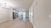 This well-appointed single-floor home features 4 bedrooms, 2 bathrooms, and a thoughtfully designed open-concept layout. Light wood-look flooring runs consistently throughout, lending a clean, cohesive aesthetic to every room. The kitchen is a standout space, showcasing gray shaker-style cabinetry, granite countertops, a classic white subway tile backsplash, stainless steel appliances, and a central island with a built-in sink — ideal for both cooking and casual dining. The kitchen flows seamlessly into the living area, creating an expansive and connected common space. The bedrooms are bright and neutral, with soft greige tones on the walls and windows that allow natural light to fill the rooms. The generously sized primary bedroom includes its own walk-in closet featuring multi-level wire shelving for organized storage. A second walk-in closet provides additional storage elsewhere in the home. Hallways connect the bedrooms to the bathrooms in a practical and efficient layout. Throughout the home, white panel doors, clean baseboards, and a neutral color palette contribute to a fresh, modern feel. The overall ambiance is light, airy, and move-in ready, offering a comfortable and functional living environment suitable for a variety of lifestyles.