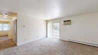 Located at 3121 Village Ct in Janesville, Wisconsin, this single-floor, 2-bedroom, 1-bathroom residence offers a practical and comfortable layout across a well-utilized floor plan. The living room serves as the heart of the home, featuring plush carpeting, a baseboard heating system, a wall-mounted air conditioning unit, and a sliding glass door that floods the space with natural light and provides outdoor access. The entry area transitions seamlessly from wood-look flooring into the carpeted living space.

The primary bedroom is a generously sized retreat, complete with a ceiling fan with light fixture, a baseboard heater, a window with natural light, and a mirrored sliding-door closet. The second bedroom, also carpeted, is bright and functional with ample wall space. A dedicated walk-in closet with wire shelving provides excellent additional storage.

The full bathroom is well-appointed with white cabinetry, a single-sink vanity, a tub-shower combination, and durable wood-look vinyl flooring, offering a clean and classic aesthetic. Throughout the home, neutral tones and white trim create a bright, cohesive atmosphere suitable for a variety of living arrangements.