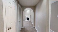This single-story, 3-bedroom, 1-bathroom home offers a thoughtfully designed layout with neutral warm-gray tones and plush carpet flooring throughout the main living areas. The living room serves as a central gathering space, highlighted by a classic white-mantled fireplace and crown molding, with an elegant arched entryway connecting it to the hallway. A ceiling fan adds comfort overhead, while recessed lighting completes the refined ambiance.

The kitchen is efficiently laid out and features white cabinetry, granite countertops, a tile mosaic backsplash, stainless steel refrigerator, and wood-look vinyl flooring — offering both style and practicality. A window brings in natural light, enhancing the clean, modern feel of the space.

Each of the three bedrooms is carpeted and equipped with a ceiling fan. The spacious primary bedroom includes crown molding, built-in shelving, and a large closet with vertical blinds allowing natural light. The additional bedrooms are well-sized and share a full bathroom featuring a tiled tub-shower combo, granite vanity, and wood-look flooring.

A dedicated laundry room accommodates a full-size washer and dryer. Two hallways connect the layout efficiently, and a closet provides additional storage. The overall design balances comfort and functionality throughout.