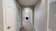 This single-story, 3-bedroom, 1-bathroom home offers a thoughtfully designed layout with neutral warm-gray tones and plush carpet flooring throughout the main living areas. The living room serves as a central gathering space, highlighted by a classic white-mantled fireplace and crown molding, with an elegant arched entryway connecting it to the hallway. A ceiling fan adds comfort overhead, while recessed lighting completes the refined ambiance.

The kitchen is efficiently laid out and features white cabinetry, granite countertops, a tile mosaic backsplash, stainless steel refrigerator, and wood-look vinyl flooring — offering both style and practicality. A window brings in natural light, enhancing the clean, modern feel of the space.

Each of the three bedrooms is carpeted and equipped with a ceiling fan. The spacious primary bedroom includes crown molding, built-in shelving, and a large closet with vertical blinds allowing natural light. The additional bedrooms are well-sized and share a full bathroom featuring a tiled tub-shower combo, granite vanity, and wood-look flooring.

A dedicated laundry room accommodates a full-size washer and dryer. Two hallways connect the layout efficiently, and a closet provides additional storage. The overall design balances comfort and functionality throughout.