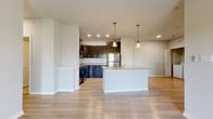 Located at 13401 Legendary Dr in Austin, TX, this well-appointed 3-bedroom, 2-bathroom single-floor residence offers a thoughtfully designed layout with a seamless blend of comfort and functionality. The heart of the home is an open-concept living, dining, and kitchen area unified by light wood-tone flooring. The kitchen is a standout, featuring rich dark espresso cabinetry, granite countertops, a subway tile backsplash, stainless steel appliances including a refrigerator, range, and microwave, and a central island with a double sink and pendant lighting above. The open layout flows naturally into the living and dining areas, creating an ideal space for entertaining. Three bedrooms are finished with plush carpet flooring and ceiling fans; each room receives natural light through window blinds. The primary bedroom includes its own closet, and the unit features four closets in total for generous storage. Both bathrooms are finished with tile flooring, dark vanity cabinetry, granite countertops, and tiled shower surrounds. A dedicated laundry area and pantry add further convenience. The private balcony is a highlight, offering sweeping views of lush Austin greenery under open skies.