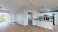 Located at 505 Regency Dr in Fayetteville, NC, this single-floor home offers a well-designed layout with a bright, open feel throughout. The expansive living room is a central highlight, featuring soaring vaulted ceilings, a ceiling fan with light fixture, plush wall-to-wall carpeting, and a classic fireplace with a white mantel. French doors lead out to a private balcony, filling the space with natural light and offering pleasant outdoor views.

The kitchen is thoughtfully appointed with white cabinetry, granite countertops, a stainless steel undermount sink, and a full suite of stainless steel appliances including a gas range, microwave, and refrigerator. A breakfast bar peninsula connects the kitchen to the living area, providing additional counter space and convenient flow.

The primary bathroom is well-equipped, featuring a separate walk-in shower, a soaking tub, light wood-style flooring, a granite-topped vanity with white cabinets, and a well-lit mirror. A secondary bathroom offers a clean, functional tub-shower combination. The bedrooms are generously sized with plush carpet, ceiling fans, and natural light from windows. The primary suite includes a spacious walk-in closet outfitted with multi-level wire shelving for ample storage. A dedicated laundry area completes the home's practical offerings.