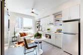 Located at 4301 Alderwood Mall Blvd in Lynnwood, WA, this one-bedroom, one-bathroom unit offers a thoughtfully designed open-concept layout that maximizes every inch of its compact footprint. The living, dining, and kitchen areas flow seamlessly together, anchored by light hardwood-style flooring and bright white walls that create an airy, modern atmosphere. A ceiling fan overhead and large windows allow natural light to pour in, offering views of the surrounding urban landscape.

The kitchen is efficiently designed with crisp white cabinetry — both upper and lower — open shelving, a single-basin sink, stainless steel refrigerator, and built-in microwave, providing all the essentials within easy reach. A stylish barn-style sliding door adds a contemporary architectural touch while separating spaces without sacrificing openness.

The bedroom is a calm, well-proportioned retreat with white walls, a window with natural light, and a sliding-door closet offering practical storage. The bathroom features a shower/tub combo with clean, neutral finishes throughout.

Throughout the unit, the design emphasizes clean lines, a neutral palette, and smart use of space, making it a functional and modern urban residence in the heart of Lynnwood.