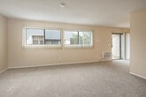 Located at 2300 Fairview Rd in Costa Mesa, CA, this 2-bedroom, 2-bathroom residence offers a well-organized, functional layout across a single floor. The open living room is finished with plush carpeting, textured ceilings, and a ceiling fan, and connects to a sliding glass door that opens onto a private balcony overlooking mature trees and neighboring rooftops — a pleasant outdoor retreat. Wall-mounted HVAC units provide climate control throughout the main living areas.

The kitchen features a wrap-around peninsula with warm-toned countertops and an integrated cooktop, complemented by white cabinetry, a dishwasher, and wood-style flooring. The layout allows for easy interaction between the kitchen and living areas.

The spacious primary bedroom includes a mirrored sliding-door closet and benefits from natural light through vertical-blind-covered windows. The second bedroom also offers generous proportions with a sliding glass door providing additional outdoor access and views. A hallway connects the bedrooms and both bathrooms. One bathroom features a shower-tub combo, while the second includes a glass-enclosed walk-in shower, both finished with wood-style flooring and warm neutral tones throughout.