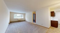 Located at 2054 South 102nd Street in West Allis, Wisconsin, this one-bedroom, two-bathroom residence offers a practical and well-organized single-floor layout. The open-concept living area combines the living room, dining room, and kitchen into one cohesive space, making efficient use of the floor plan. The living room is carpeted and features a large window that brings in natural light, along with baseboard heating and a ceiling fan in the adjoining area. Warm wood-toned trim and doorframes add a consistent design element throughout.

The kitchen is equipped with dark wood cabinetry and includes a range, with tile flooring providing a clean transition from the carpeted living areas. The primary bedroom is a comfortable size, carpeted, with a window overlooking greenery and its own baseboard heating. A wide louvered bifold closet provides ample storage within the bedroom, and two additional closets elsewhere in the unit offer further organization options.

The two bathrooms serve distinct functions: one features a full tub and shower with classic yellow tile surround, while the other offers a vanity with a wide marble-style countertop, dark wood cabinetry, and tile flooring with overhead lighting. Together, they provide practical convenience for daily living.