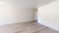 Located at 1701 Ellis Lake Drive in Marysville, California, this one-bedroom, one-bathroom unit offers a practical and comfortable single-floor layout. The open-concept living room and kitchen area forms the heart of the home, finished with light-toned luxury vinyl plank flooring that lends a clean, contemporary feel throughout. The kitchen is equipped with warm wood cabinetry, a white speckled countertop with a peninsula-style breakfast bar, a stainless steel sink, black appliances including a refrigerator and gas range, and overhead cabinet storage — all centered around a window that brings in natural light. The living area is bright and open with crisp white walls and ample space for flexible furniture arrangements. The bedroom is a well-proportioned, carpeted retreat with a window overlooking the outdoors, providing natural light and a peaceful ambiance. A dedicated closet offers convenient storage. The full bathroom features warm wood vanity cabinetry, a wide countertop with an integrated sink, a large mirror with overhead lighting, a medicine cabinet, and light wood-tone flooring. Ceiling vents provide central air circulation throughout the unit. Clean, neutral finishes make this a move-in-ready space suitable for a variety of living styles.
