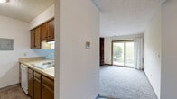 Located at 2000 Westown Pkwy in West Des Moines, Iowa, this one-bedroom, one-bathroom unit offers a practical and functional layout across a single floor. The galley-style kitchen is well-appointed with rich wood cabinetry, light butcher block countertops, hardwood-style flooring, and a full suite of appliances including a refrigerator, electric range, dishwasher, and over-the-range microwave. The kitchen opens into the living area, which features a ceiling fan and connects smoothly to the rest of the unit. The bedroom is a comfortable, well-proportioned space finished with plush carpeting, a ceiling fan, a window that brings in natural light, and a textured ceiling. A standout feature of the bedroom is the dual sliding wood-panel closets, offering generous storage. The bathroom includes an extended white vanity with ample cabinet storage beneath, a wide mirror with overhead lighting, and a shower/tub combination. Hardwood-style flooring continues through the bathroom, tying the unit together with a cohesive aesthetic. This unit is a well-maintained, efficiently designed space ideal for those seeking comfortable single-floor living in West Des Moines.