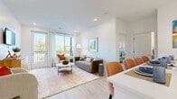Located at 8770 Galaxy Way in Columbus, Ohio, this well-designed two-bedroom, two-bathroom residence offers a thoughtfully laid-out single-floor plan with generous living space. The open-concept kitchen and living area serves as the heart of the home, featuring gray shaker-style cabinetry, stainless steel appliances, a large center island with seating for multiple bar stools, white quartz countertops, and elegant pendant lighting. Light hardwood flooring flows throughout, complementing the bright, neutral color palette. The living area is bathed in natural light from large windows and a glass door that opens to a private balcony with outdoor views. The primary bedroom offers a comfortable retreat with a walk-in closet and an en-suite bathroom featuring gray vanity cabinetry and wood-tone flooring. The second bedroom also includes a dedicated closet and a sizable window with views of the surrounding greenery. With six closets total, storage is abundant throughout. Both bathrooms are finished with clean, modern fixtures. A dedicated in-unit laundry area adds everyday convenience. The overall ambiance is modern and airy, with recessed lighting and consistent finishes tying the entire space together cohesively.