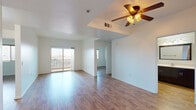 This 2-bedroom, 1-bathroom residence is thoughtfully laid out across a single floor, offering a comfortable and functional living environment. The open living room is a standout space, featuring warm wood-look flooring, a tray ceiling with a ceiling fan and light fixture, and a sliding glass door that leads to a private balcony with outdoor views, filling the room with natural light.

The kitchen is designed for efficiency, with a U-shaped layout offering ample light wood cabinetry, granite-style countertops, a gas range, over-the-range microwave, and a stainless steel sink — providing generous workspace and storage.

Both bedrooms are bright and comfortable, each benefiting from natural light through windows fitted with blinds. The primary bedroom includes a sliding closet with a built-in hanging rod, offering practical storage. The second bedroom, though more compact, maintains the same clean aesthetic and wood-look flooring found throughout the home.

The bathroom is well-appointed with a dark wood vanity, light countertop, and matching wood-look flooring that ties the space together cohesively.

A hallway connects the main living areas to the bedrooms and bathroom, ensuring a logical and easy-to-navigate floor plan. Clean white walls and consistent flooring throughout give the entire residence a bright, unified feel.
