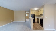 This one-bedroom, one-bathroom unit is located at 4727 200th St SW in Lynnwood, WA, offering a practical and well-organized single-floor layout. The open-concept main area seamlessly connects the living room, dining space, and kitchen, creating a cohesive and functional environment. The kitchen features wood-look flooring, cream cabinetry, black appliances including a refrigerator, electric range, and dishwasher, along with a peninsula counter that serves as a natural divider from the carpeted living area. Large windows in the living room allow natural light to fill the space and provide views of the surrounding greenery and community pool area. The bedroom is a comfortable size, appointed with plush carpet, warm neutral-toned walls, and a sliding door closet. An additional closet offers extra storage. The full bathroom includes a tub/shower combination, a vanity with a speckle-finish countertop, and a mirror. A dedicated laundry closet houses a stacked washer and dryer unit alongside a water heater, adding everyday convenience. Textured ceilings and warm beige walls carry throughout, giving the space a consistent and cohesive feel.