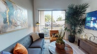 Located at 7370 S La Tijera Blvd in Los Angeles, CA, this single-floor residence offers a thoughtfully designed interior with a contemporary aesthetic throughout. The living area serves as the heart of the home, featuring light wood-style flooring, a large sliding glass door, and direct access to a private balcony that invites natural light and outdoor views. The space is complemented by neutral tones, curated wall art, and lush indoor greenery that add warmth and character.

The kitchen is a standout feature, outfitted with rich dark wood cabinetry extending to the ceiling, white quartz countertops, a subway tile backsplash, and a full suite of stainless steel appliances including a gas range, microwave, dishwasher, and side-by-side refrigerator. Recessed lighting and light wood flooring enhance the clean, modern finish.

The bedroom offers a serene retreat, highlighted by a bold navy accent wall, a large window with natural light, and a plush tufted headboard as a focal point. The bathroom features a spacious walk-in shower with large-format tile, a glass enclosure, and clean, minimalist finishes. Together, these spaces create a cohesive, well-appointed living environment in a convenient Los Angeles location.