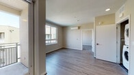 Located at 505 Lincoln Ave in the heart of San Jose, CA, this thoughtfully designed single-floor residence offers a clean, contemporary aesthetic with functional living spaces. The open living area is highlighted by wide-plank hardwood-style flooring, neutral toned walls, and a large sliding window that draws in abundant natural light while offering views of the surrounding community. A wall-mounted split AC unit ensures year-round climate comfort.

The kitchen is a standout feature, showcasing warm wood cabinetry extending to the ceiling, crisp white countertops, a mosaic tile backsplash, and a full suite of stainless steel appliances including a side-by-side refrigerator with ice and water dispenser, a glass-top range with oven, and an over-the-range microwave. The space is both stylish and highly practical.

The bedroom is carpeted for comfort and benefits from its own large window, filling the room with natural light. The bathroom is finished with hardwood-style flooring, a floating wood vanity with white countertop, an undermount sink, and a large framed mirror. A dedicated in-unit laundry closet with stacked washer and dryer adds exceptional convenience. Together, these elements create a cohesive, modern living environment.