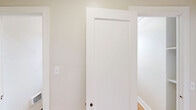 Located at 1330 Boren Ave in Seattle, WA, this one-bedroom, one-bathroom unit offers a thoughtfully arranged single-floor layout. The spacious bedroom features warm hardwood flooring, a ceiling fan, and a wide multi-pane window that fills the room with natural light and frames views of the surrounding Seattle cityscape. A dedicated closet provides convenient built-in storage.

The galley-style kitchen is well-appointed with white shaker cabinetry lining both walls, granite-patterned countertops, a double stainless steel sink with a brushed gold faucet, and white appliances including a range and refrigerator. A window above the range brings in additional natural light, while durable stone-tile flooring adds a clean, practical finish.

The bathroom continues the tile flooring found in the kitchen and features a pedestal sink, a wall-mounted vanity light, and a window that brightens the space naturally. A hallway connects the main areas of the unit, contributing to an efficient and logical flow throughout.

The unit's clean white walls, consistent finishes, and mix of hardwood and tile flooring create a cohesive, bright ambiance. Situated in the heart of Seattle, this unit combines functional design with an accessible urban location.