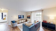 Located at Silver Lake Blvd in Alexandria, VA, this 2-bedroom, 1-bathroom residence offers a well-designed single-floor layout that makes efficient use of its space. The living room serves as the heart of the home, featuring warm hardwood-style flooring, neutral walls, and a large sliding glass door that opens to a private balcony, flooding the room with natural light and providing outdoor views of the surrounding neighborhood. The kitchen is thoughtfully appointed with white cabinetry, dark granite-style countertops, stainless steel appliances including a range, refrigerator, and dishwasher, and a cozy dining nook — all set atop matching hardwood-style flooring. Both bedrooms are carpeted and bright, each featuring multiple windows that frame greenery and outdoor views, creating a calm and restful atmosphere. The primary bedroom offers a comfortable footprint with generous natural light. The shared bathroom includes a shower/tub combination, a wood-toned vanity, and hardwood-style flooring, keeping the design cohesive throughout. The overall ambiance of the residence is clean, bright, and welcoming, with a neutral color palette that provides a versatile backdrop for any style of living.