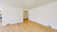 Located at 8000 High School Rd in Elkins Park, PA, this single-floor, 2-bedroom, 1-bathroom unit offers a practical and comfortable layout. The living room is bathed in natural light from multiple windows with blinds, and features light wood laminate flooring that extends throughout the main living areas, creating a clean, cohesive look.

The kitchen is well-appointed with warm honey-toned wood cabinetry, dark countertops, a tile backsplash, and a full suite of white appliances including a gas range, built-in microwave, and dishwasher. A window above the sink allows for additional natural light, and there is generous counter and storage space throughout.

Both bedrooms are carpeted in a neutral tone, providing a comfortable feel. The spacious primary bedroom includes two closets and ample room to furnish. The second bedroom also features a window with natural views and a floor vent for climate control.

The bathroom is bright and clean, featuring white subway tile wainscoting, a soaking tub, a white vanity, and a window that allows in natural light. Two hallways connect the rooms efficiently throughout the unit. The overall aesthetic is neutral and move-in ready, with a functional design suited for everyday living.