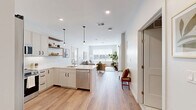 Located at 770 Water Street in Framingham, MA, this thoughtfully designed 2-bedroom, 2-bathroom residence offers a seamless blend of modern aesthetics and functional living. Light-toned hardwood flooring flows throughout the open-concept main area, connecting the kitchen, dining, and living spaces in a cohesive and airy layout.

The kitchen is well-appointed with white shaker-style cabinetry, stainless steel appliances, a subway tile backsplash, a central island with sink, open floating wood shelves, and stylish pendant lighting. The adjacent living room is bright and welcoming, anchored by a wide picture window that invites generous natural light and outdoor views.

The primary bedroom is a comfortable retreat, featuring large windows with exterior views and light hardwood floors. The second bedroom is equally well-sized and bright. Both bathrooms are finished with clean, contemporary details — one features rich wood-toned cabinetry, a white quartz countertop, and distinctive hexagonal tile flooring, while the second bath mirrors the same refined tile work. Each bedroom is complemented by a dedicated closet for ample storage.

Throughout the residence, a neutral color palette, recessed lighting, and clean architectural lines create a calm, modern ambiance suited for everyday living.