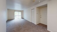 Located at 4300 Alpenhorn Dr NW in Comstock Park, Michigan, this single-floor residence offers a well-organized layout designed for comfortable everyday living. The open living area is finished with neutral-toned carpet and features a large sliding glass door with vertical blinds, filling the space with natural light and providing direct access to an outdoor balcony with views of surrounding greenery. A ceiling fan overhead adds to the functionality of the room, while a closet and entry door are conveniently positioned nearby. The bedroom is generously sized, featuring plush carpeting, a ceiling fan with light fixture, a louvered closet door, and two windows that invite abundant natural light and outdoor views. The kitchen is equipped with rich, dark wood cabinetry offering ample storage, light countertops, a double-basin stainless steel sink, under-cabinet lighting, and a black dishwasher. The bathroom is clean and practical, with tile flooring, a full tub-and-shower combo with built-in shelving, a vanity with wood cabinetry, and brushed nickel fixtures. The overall ambiance of the space is bright and neutral, with a straightforward, functional design throughout.