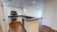 Located at 550 Moreland Way in Santa Clara, California, this single-floor residence offers a thoughtfully designed open-concept layout that seamlessly connects the living, dining, and kitchen areas. Rich hardwood flooring flows throughout the space, adding warmth and cohesion to every room.

The kitchen is a standout feature, outfitted with crisp white shaker cabinetry, dark granite countertops, and a full suite of stainless steel appliances including a gas range, built-in microwave, dishwasher, and refrigerator. Recessed and track lighting illuminate the space, while a peninsula counter provides additional prep space and serves as a natural divider between the kitchen and living area.

The living area is generously proportioned, bathed in natural light from large sliding glass doors that open to a private balcony with outdoor views of the surrounding Santa Clara neighborhood. The clean white walls and open layout create a bright, airy ambiance throughout.

The bathroom continues the home's consistent design language, featuring granite countertops, white cabinetry, a large vanity mirror, and a tub-shower combination with granite tile surround. An in-unit washer and dryer are also conveniently included. Overall, the space presents a clean, modern aesthetic well-suited for comfortable everyday living.