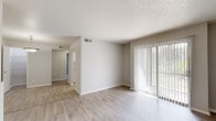 Located at 7932 Southside Blvd in Jacksonville, Florida, this single-story unit offers a clean, functional layout with a neutral color palette throughout. The main living area is open and well-lit, featuring light wood-style flooring and a standout fireplace with a tile hearth that serves as a natural focal point. Large sliding glass doors fitted with vertical blinds allow generous natural light to fill the space while providing direct views of the lush greenery outside. The layout flows seamlessly from the living area toward the rest of the unit, connecting to a dedicated dining area illuminated by a pendant light fixture. The kitchen is well-appointed with white cabinetry, ample counter space featuring speckled laminate countertops, a double stainless steel sink, and a dishwasher — offering both practicality and storage. The bedroom is comfortably sized with a window that frames outdoor views, continuing the light and airy feel carried throughout the home. The bathroom features a full tub and shower combination, a vanity with matching cabinetry and countertop, and wood-style flooring. Textured ceilings are consistent throughout the unit, adding a classic finish. Overall, the space presents a bright, livable environment with a cohesive design and functional features.