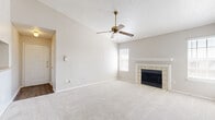 Located at 4035 Towne Crossing Blvd in Mesquite, TX, this one-bedroom, one-bathroom residence offers a practical and comfortable single-floor layout. The living room serves as the heart of the home, highlighted by a tile-surround wood-burning fireplace with a white mantel and complemented by a ceiling fan overhead. Soft carpet flooring, a textured ceiling, and multiple windows with blinds allow natural light to fill the space, creating a bright and neutral atmosphere. A door from the living area provides direct exterior access. The kitchen is connected via an open pass-through and features warm wood-toned cabinetry, a range, and a breakfast bar area, keeping the space functional and accessible. A hallway connects the living area to the private bedroom, which is generously proportioned and finished with plush carpet and ample wall space. Two closets—including a walk-in style closet with built-in shelving and rods—provide substantial storage. The bathroom is finished with wood-look luxury vinyl plank flooring and includes a full tub and shower combination with tiled surround. Clean, neutral tones throughout the home create a cohesive and move-in ready environment.