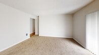 Located at 10413 SE 174th St in Renton, WA, this 2-bedroom, 1-bathroom single-floor home offers a well-organized layout across a comfortable footprint. The living room is a bright, open space with plush carpeting, neutral walls, and a large window fitted with vertical blinds that invite natural light while offering privacy. The textured ceiling and clean white trim are consistent throughout the home, lending a cohesive aesthetic.

The galley-style kitchen is a functional highlight, featuring warm honey-toned wood cabinetry lining both sides, white countertops, and light hardwood-style flooring. White appliances including a range, refrigerator, and dishwasher are thoughtfully integrated, and ample upper and lower cabinet storage makes the space highly practical.

Both bedrooms are carpeted and finished in soft neutral tones, with windows providing natural light and views of the surrounding area. The primary bedroom is generously sized and is served by a walk-in closet with built-in double hanging rods and shelving for organized storage. A second closet serves the additional bedroom.

The bathroom features warm wood-toned cabinetry, white countertops, a mirror, and hardwood-style flooring, maintaining the home's consistent design language. A utility room and hallway complete the efficient floor plan, making this a well-rounded and practical home.