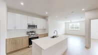 Located in McKinney, TX, this thoughtfully designed one-bedroom, one-bathroom residence offers a clean, modern aesthetic across a single floor. Light wood-style flooring runs throughout the entire space, creating a warm and cohesive feel that ties each room together seamlessly.

The open-concept kitchen and living area serves as the heart of the home. The kitchen is outfitted with stainless steel appliances, including a French door refrigerator with ice maker, electric range, and over-the-range microwave. A two-tone cabinetry design pairs crisp white upper cabinets with natural wood-toned lower cabinets, complemented by subway tile backsplash and white quartz countertops. A central island with a built-in sink adds both workspace and casual dining functionality.

The bedroom is a bright and airy retreat, featuring dual windows that invite generous natural light and views of the surrounding neighborhood. A ceiling fan adds comfort, and the room offers ample space for a variety of furniture arrangements.

The bathroom is clean and well-appointed, showcasing a wood-toned vanity with white countertop, a tub-shower combination with white subway tile surround, and light flooring that continues the home's consistent design language. A spacious walk-in closet accessible through the bathroom provides excellent storage. The overall ambiance is fresh, minimalist, and move-in ready.