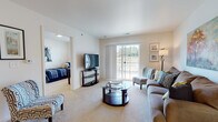 Located at 4248–4298 Maue Rd in Miamisburg, Ohio, this single-floor residence offers a thoughtfully designed layout that balances comfort and functionality throughout. The living room serves as the heart of the home, featuring plush carpeting, neutral walls, and a large sliding glass door that floods the space with natural light and provides direct access to an outdoor patio with open views of the surrounding landscape. The kitchen is well-equipped with rich warm-toned cabinetry, granite-style countertops, stainless steel appliances including a dishwasher and range, and durable tile flooring. Adjacent to the kitchen, the dining area comfortably accommodates a full dining set beneath a pendant light fixture, creating an inviting space for meals. The bedrooms are carpeted and bright, each receiving natural light through sizable windows. One bedroom includes a dedicated desk area, offering versatility as a home office. The bathroom is designed with accessibility in mind, featuring safety grab bars, tile flooring, a warm wood vanity, and a glass-door shower enclosure. Throughout the residence, a cohesive palette of neutral tones and warm wood accents creates a welcoming and well-balanced ambiance.