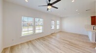 Located at 349 Ridge Rd in Lafayette, Louisiana, this well-appointed 2-bedroom, 2-bathroom residence offers a thoughtfully designed single-floor layout. Light wood-look flooring runs throughout, creating a cohesive and bright atmosphere across all rooms. The open-concept kitchen and living area serves as the heart of the home, featuring warm honey-toned cabinetry, a subway tile backsplash, light quartz countertops, a kitchen island with a sink, and a full suite of stainless steel appliances including a refrigerator, range, and built-in microwave. The living area extends toward a glass-panel exterior door flanked by windows fitted with blinds, inviting natural light and outdoor views. The generously sized primary bedroom includes a ceiling fan and large windows overlooking the exterior. The second bedroom also features a ceiling fan, a closet with double doors, and a natural light source. Both bathrooms are finished with warm wood vanities, white countertops, and tub-shower combinations. A dedicated laundry room with shelving and washer/dryer hookups adds everyday convenience. Clean white walls, recessed lighting, and consistent flooring throughout lend the space a modern, move-in-ready appeal.