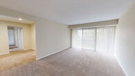 Located at 1136 Georgetown Rd in Norfolk, VA, this single-floor, 2-bedroom, 2-bathroom residence offers a thoughtfully organized layout across a comfortable footprint. The living room is bright and open, featuring large sliding glass doors with vertical blinds that invite abundant natural light and offer views of the surrounding greenery. Neutral-toned carpeting runs throughout the living areas and bedrooms, contributing to a warm, cohesive atmosphere. The galley-style kitchen is well-appointed with rich wood cabinetry, granite-style countertops, a mosaic tile backsplash, black appliances including a gas range and refrigerator, and light hardwood-style flooring. A separate dining room and pantry add to the functional layout. Both bedrooms are generously sized, with the primary bedroom offering a spacious closet with bi-fold doors. The second bedroom also includes closet storage and its own sliding glass door for natural light. The bathrooms are clean and bright, featuring large mirrors and white fixtures. Additional highlights include a dedicated laundry area, multiple closets throughout, and a connecting hallway that ties the layout together efficiently.