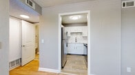 This single-floor unit offers a clean, contemporary interior with a neutral gray color palette and white trim throughout, creating a bright and cohesive aesthetic. The main living areas feature light wood-style plank flooring that extends seamlessly across the open layout, while textured ceilings add a classic touch overhead. Large windows in the living and bedroom areas allow natural light to fill the space, with views of the surrounding outdoors.

The kitchen is a standout feature, outfitted with crisp white shaker-style cabinetry, light quartz-look countertops, and a classic white subway tile backsplash. Stainless steel appliances, including a full-size refrigerator and range, complete the modern, functional design. The kitchen connects conveniently to the main living area, supporting an easy flow throughout the unit.

The bedroom is carpeted in a warm neutral tone, offering comfort underfoot, and is finished with the same gray walls and textured ceiling found throughout the home. The bathroom includes a full tub-shower combination with white tile surround, wood-style flooring, and clean, simple fixtures. Additional storage and closet space is accessible from the main hallway, rounding out this efficiently designed single-level living space.