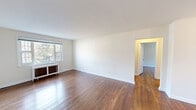 Located at 841 Highland Avenue in Jenkintown, PA, this two-bedroom, one-bathroom residence offers a practical and comfortable single-floor layout. Rich hardwood floors run throughout the main living areas and bedrooms, lending warmth and continuity to the space.

The living room is generously sized, featuring bright white walls, gleaming hardwood floors, and a window that invites natural light. A classic cast-iron radiator provides character alongside the modern surroundings. The space flows naturally through a wide doorway into additional rooms.

Both bedrooms are well-proportioned with hardwood flooring, ceiling fans, and windows fitted with blinds. The primary bedroom is notably spacious, offering room for a full furniture arrangement, and includes a closet with paneled doors. Radiator heating units are present in each bedroom.

The kitchen is efficiently designed with light wood cabinetry, dark granite-style countertops, tile flooring, and a full suite of white appliances including a gas range, over-the-range microwave, and ample counter space. A window above the counter provides natural light.

The bathroom features classic white subway-style wall tiles with a dark tile border accent, a shower/tub combination with chrome fixtures, and connects directly to the hallway. A connecting hallway with hardwood flooring ties all rooms together cohesively.
